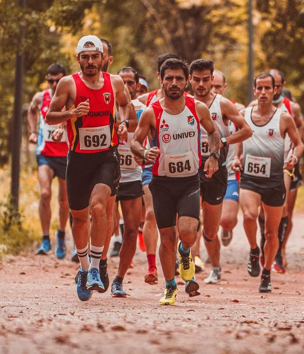 Woman in athletic wear performing a dynamic cardio movement with a focused expression.